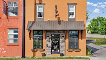 A building with a storefront, a signboard, and a door with a window.