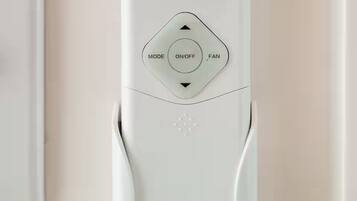 A white Pioneer thermostat with a digital display, mode, on/off, and fan buttons.