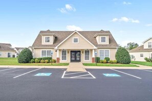 A two-story building with a central entrance, parking lot, and wheelchair-accessible spaces.