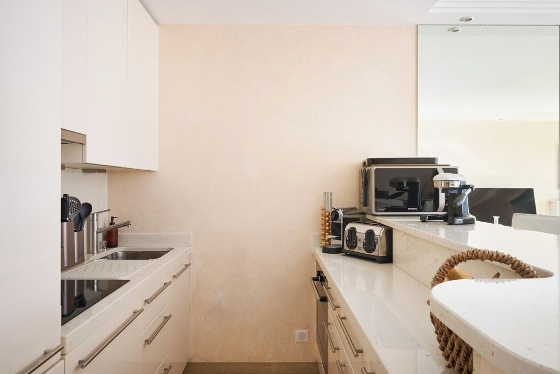 A compact kitchen with a built-in stove, a coffee maker, and a toaster.