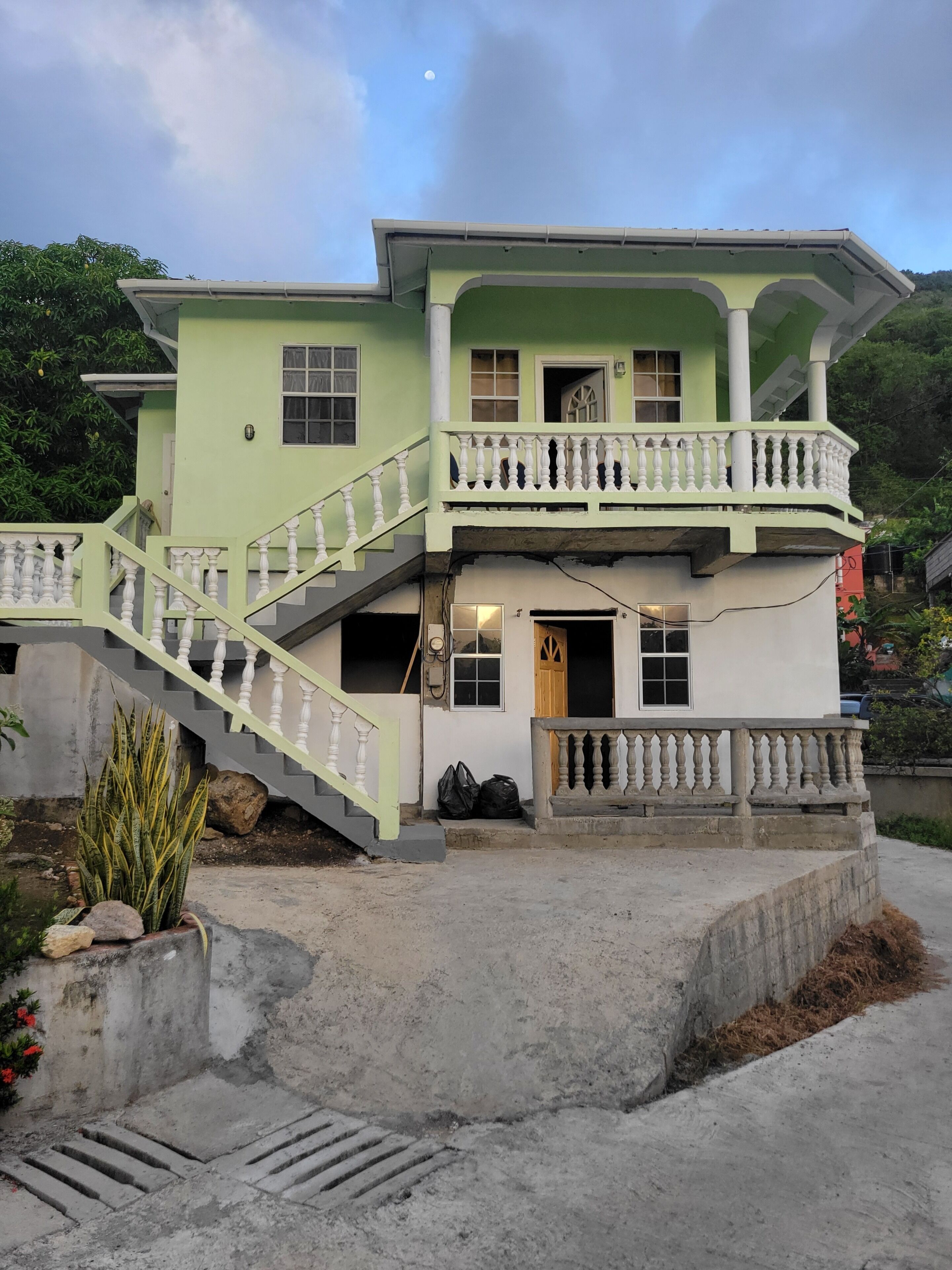 A two-story house with a balcony, a staircase, and a front door.