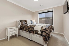 A bedroom with a bed, nightstand, and window. - Robinson Retreat - Sleeps 8, Pet Friendly (Orange)