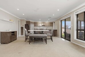 A spacious kitchen with a dining area, a built-in oven, and a large sliding glass door to the outdoors. - Robinson Retreat - Sleeps 8, Pet Friendly (Orange)