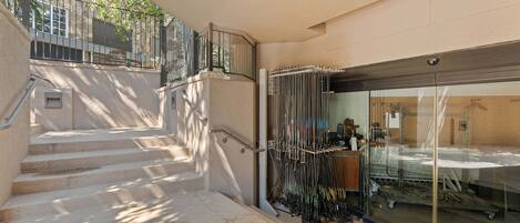 A staircase leading to a building entrance with a metal railing and a glass door.