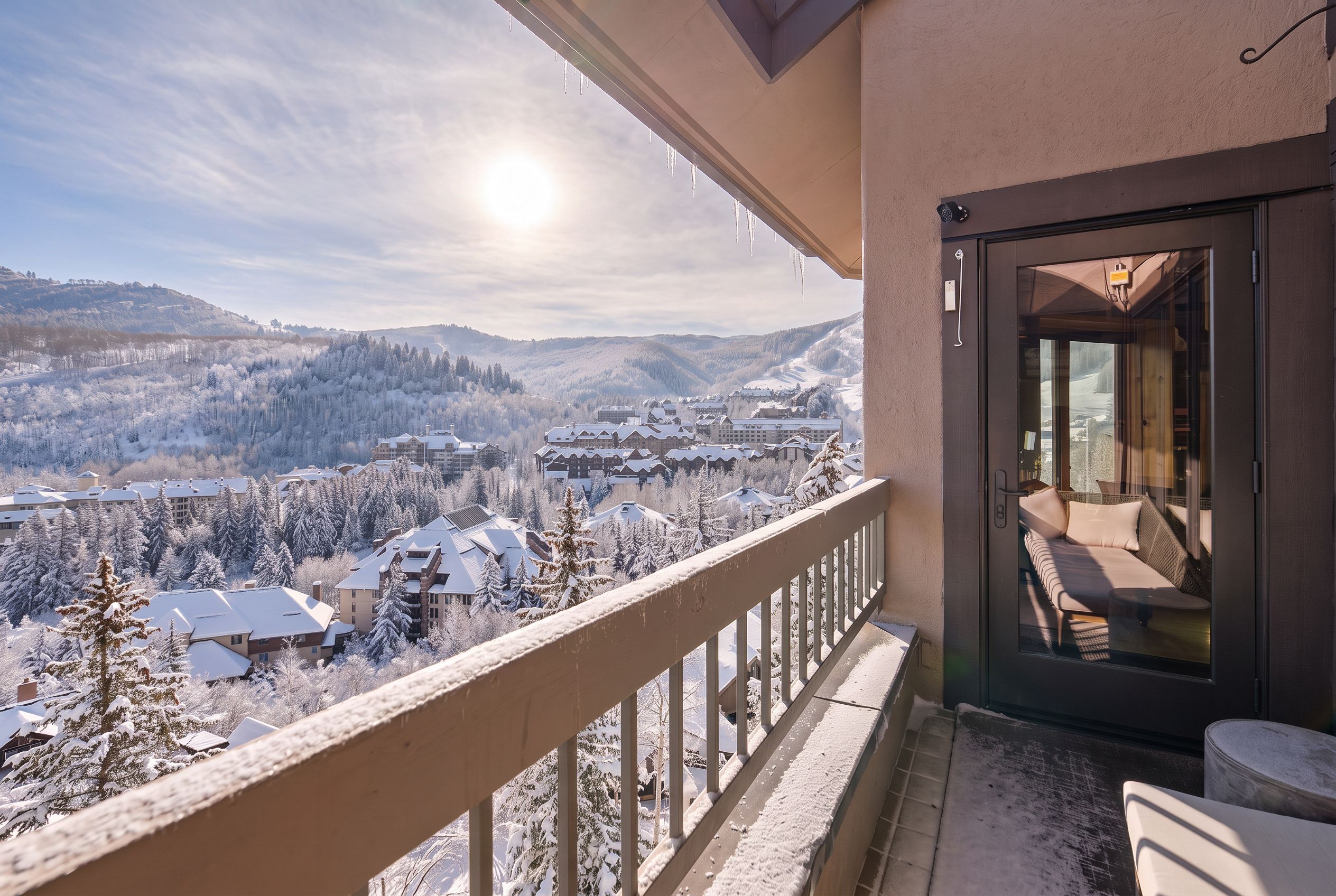 Ein Balkon mit Blick auf ein verschneites Dorf und Berge.