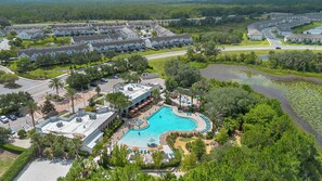 A resort with a swimming pool, multiple buildings, and a road. - 4BR Family Townhome, pool, resort & Splash (Davenport)