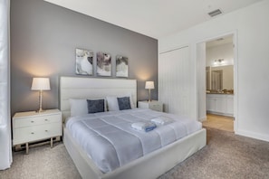 A bedroom with a bed, bedside tables, and artwork on the wall. - 4BR Family Townhome, pool, resort & Splash (Davenport)