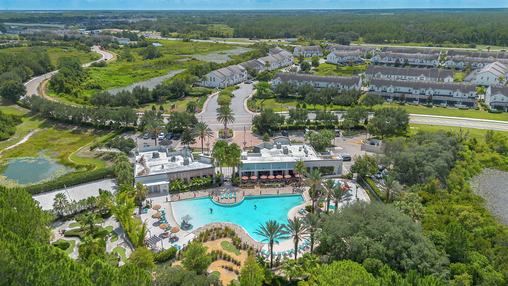 A resort with a swimming pool, guest rooms, and a golf course.