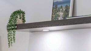 A kitchen counter with a coffee maker, a microwave, a wooden cutting board, and a hanging plant. - SeaEden @ The Temple Studio Spa Apartment (Craiglie)
