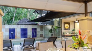 An outdoor dining area with a pool, chairs, and a table set for two. - SeaEden @ The Temple 3 Bedroom with Private Pool (Craiglie)