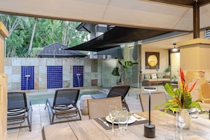 An outdoor dining area with a pool, chairs, and a table set for two. - SeaEden @ The Temple 3 Bedroom with Private Pool (Craiglie)