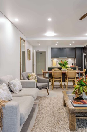 Ein modernes Wohnzimmer mit einer Couch, einem Couchtisch und einem Essbereich mit Stühlen und einem Tisch.