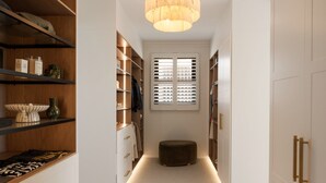 A hallway with a central light fixture, wooden shelving, and a bench. - The Sanctuary by Aryve (Mermaid Waters)