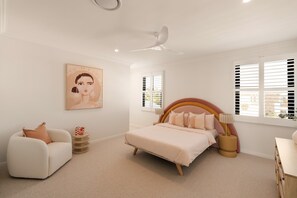 A bedroom with a bed, a chair, a bedside table, a lamp, a ceiling fan, and a window with blinds. - The Sanctuary by Aryve (Mermaid Waters)