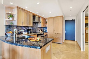 Eine moderne Küche mit Granit-Arbeitsplatten, Holzschränken und Edelstahlgeräten.