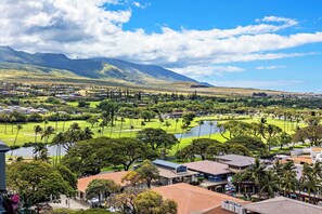Ein Wohngebiet mit Häusern, einem Golfplatz und einem Berg im Hintergrund.