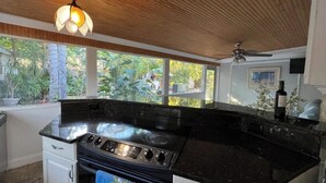 A kitchen with a stove, oven, and a hanging light fixture. - Charming 1-bedroom Guesthouse in Amazing Ozona Free Parking, Walk to Restaurants (Palm Harbor)