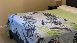 A room with a bed, a nightstand, a lamp, and a framed picture on the wall. - 3-bedroom flat in Cypress ,second floor with independent entrance  (Cypress)