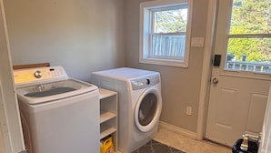A laundry room with a washing machine, dryer, and a window.