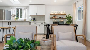 Un soggiorno moderno con due poltrone, un tavolino e una libreria con oggetti decorativi.