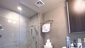 Un bagno moderno con doccia a vetro, un WC e un lavandino con specchio sopra.