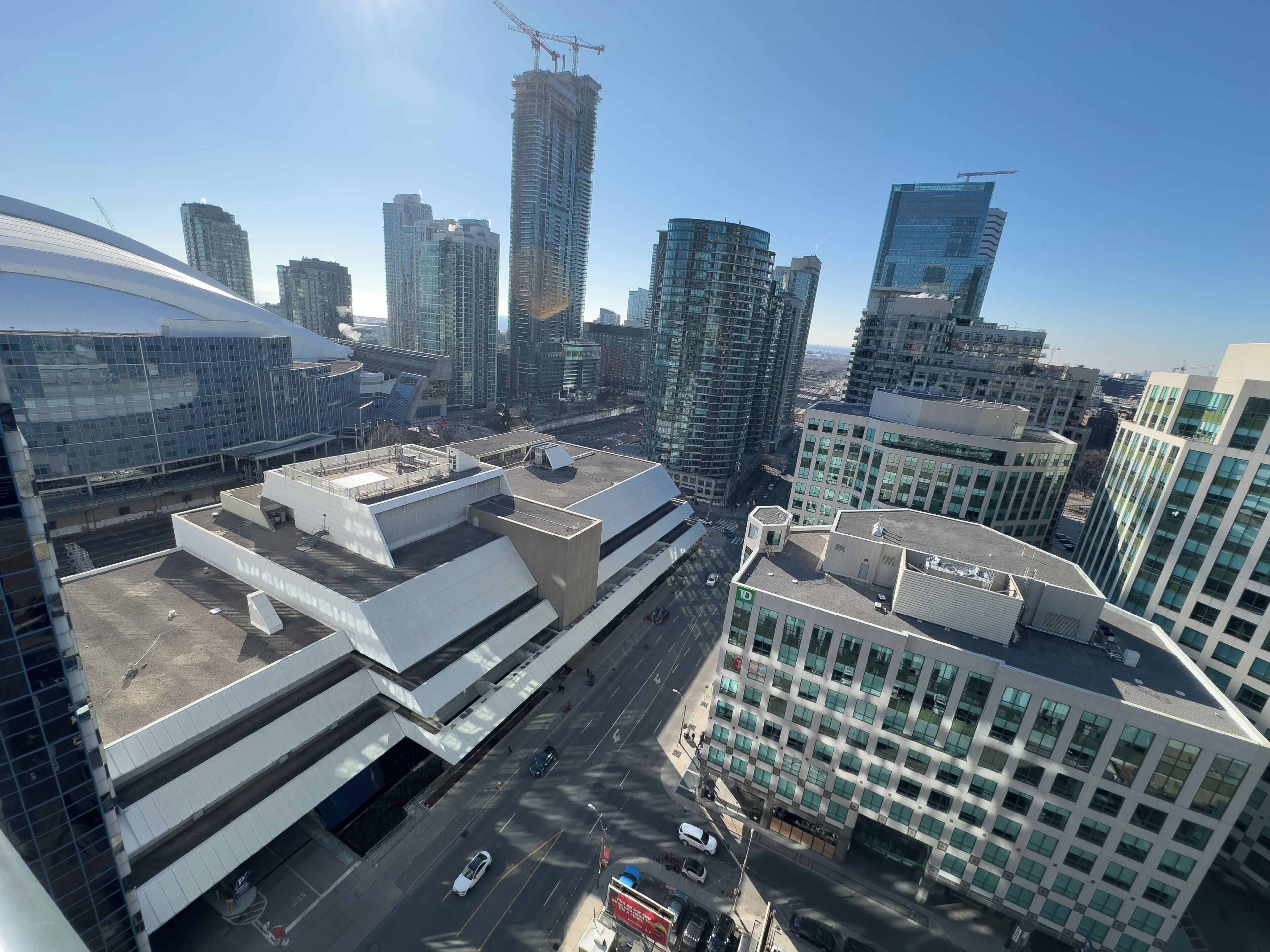 A modern urban skyline with high-rise buildings, including a distinctive curved structure and a building with a large glass facade.