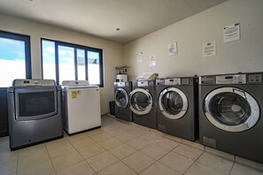A laundry room with four washing machines, a dryer, and a refrigerator. - 2 King Beds | Rooftop Pool | Walk to Beach & 5th Ave (Playa del Carmen)