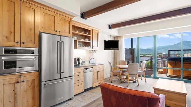 Una cucina moderna con mobili in legno, elettrodomestici in acciaio inossidabile e un'area pranzo con vista.