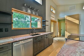 A modern kitchen with a large window, built-in cabinets, and a dishwasher. - Ramblewood Lodging 1 (Athens Township)