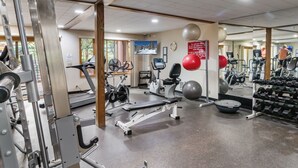 Uma academia com diversos equipamentos de exercício, incluindo esteiras, bicicletas ergométricas e aparelhos de musculação.