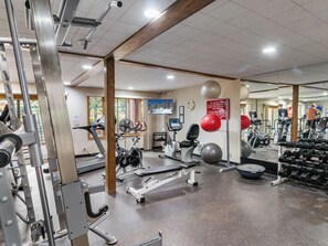 Ein Fitnessstudio mit verschiedenen Trainingsgeräten, darunter Laufbänder, Ergometer und Kraftgeräte.