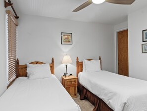 A bedroom with two single beds, wooden headboards, a nightstand with a lamp, and a ceiling fan. - Snow Flower 152 | Ski-In/Ski-Out | Loft | Mountain Views | Pool & Hot Tub (Park City)