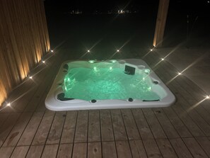 A hot tub on a wooden deck at night. - Villa with panoramic views, pool & spa, sleeps 12, pets allowed (Virazeil)