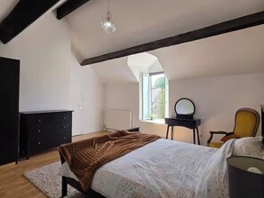 A bedroom with a bed, a dresser, a chair, a desk, and a window. - Traditional Stone Country House in Normandy (Passais Villages)