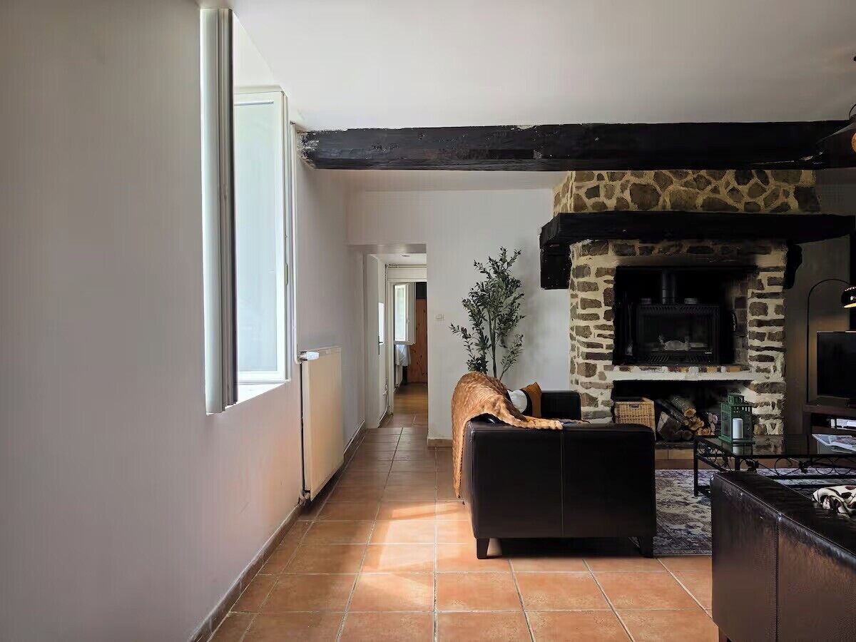 Ein Wohnzimmer mit Kamin, einer Couch und einem Fernseher.