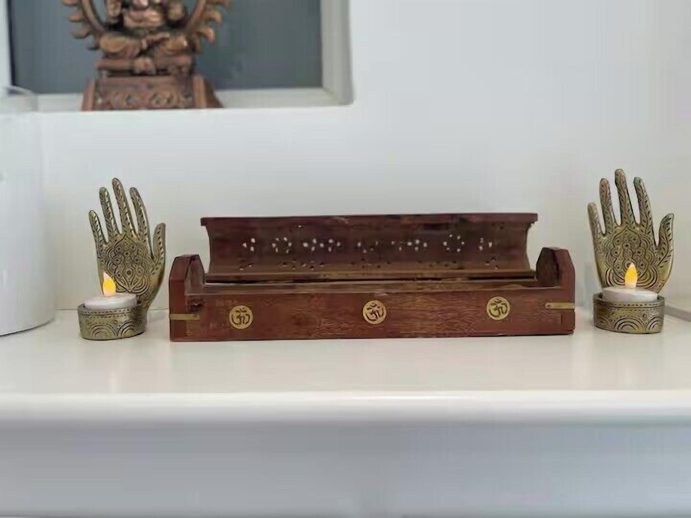 Un plateau en bois, avec un porte-bougie à chaque extrémité, posé sur une surface blanche.