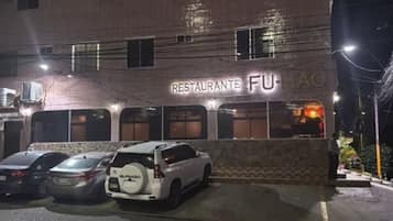 Un edificio con un letrero que dice 'RESTAURANTE FUHAO' y un estacionamiento con varios coches.