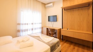 Ein Hotelzimmer mit einem Bett, einem Schreibtisch, einem Stuhl und einem Fernseher.