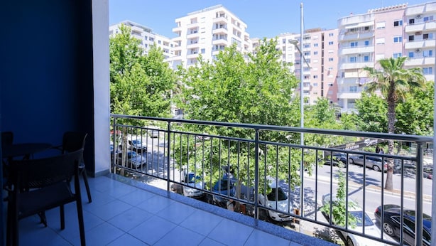 Ein Balkon mit Blick auf ein Wohngebiet, inklusive geparkter Autos und Gebäuden.