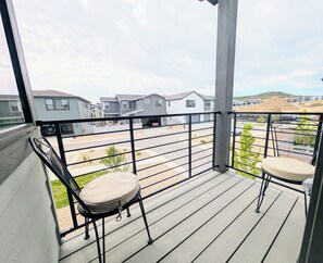 A balcony with a view of a residential area, including houses and a road. - Modern 1BR/1BA with Attached Garage private entrance and Patio (Lone Tree)