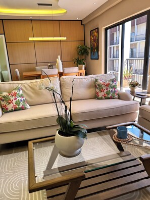 A modern living room with a sofa, a coffee table, and a potted plant. - Charming 2-bedroom apartment with AC in perfect Puerto Plata (Puerto Plata)