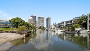 Une vue sur le front de mer, avec des bâtiments modernes, une rivière paisible et un port de plaisance rempli de bateaux.