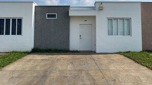 Ein modernes, zweistöckiges Haus mit befestigter Auffahrt und einer weißen Garagentür mit der Aufschrift '21F'.