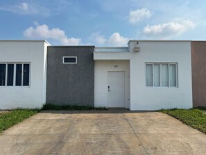 Ein modernes, zweistöckiges Haus mit befestigter Auffahrt und einer weißen Garagentür mit der Aufschrift '21F'.