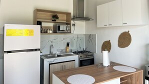 Eine moderne Küche mit Kühlschrank, Mikrowelle, Herd und Schränken.