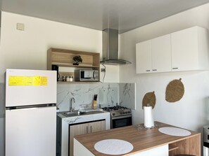 Eine moderne Küche mit Kühlschrank, Mikrowelle, Herd und Schränken.