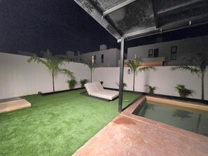 A rooftop pool area with artificial grass, a lounge chair, and a small pool. - 3-bedroom house (Mérida)