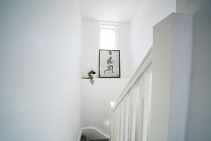Una escalera estrecha con un cuadro en la pared.