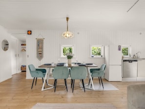 Eine moderne Küche mit weißen Schränken, einem integrierten Geschirrspüler und einem Fenster für natürliches Licht.