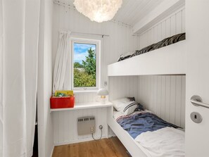 A compact room with a bunk bed, a desk with a lamp, a window with curtains, and a red storage box. - "Ulli" - 350m from the sea by Interhome (Grenaa)